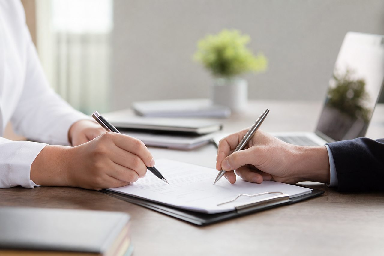 Salarié et responsable RH signant un document dans un bureau moderne et lumineux